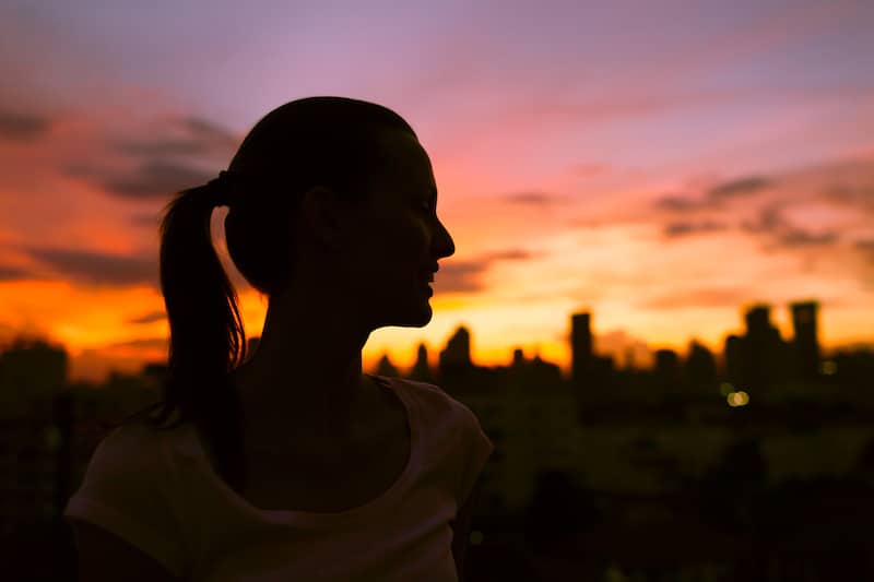 Healthy young woman enjoying sunset, finding balance Anorexia and Crohn's