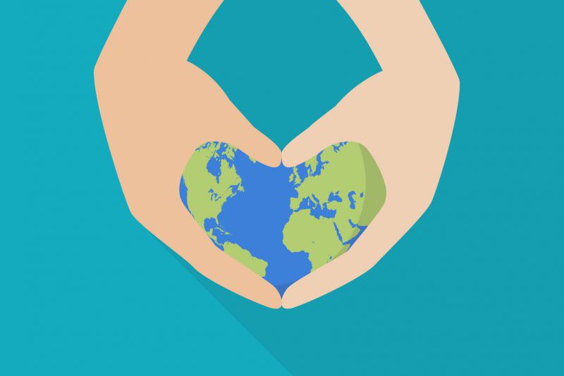 Hands holding the earth in a heart shape; helping others with ostomies around the world